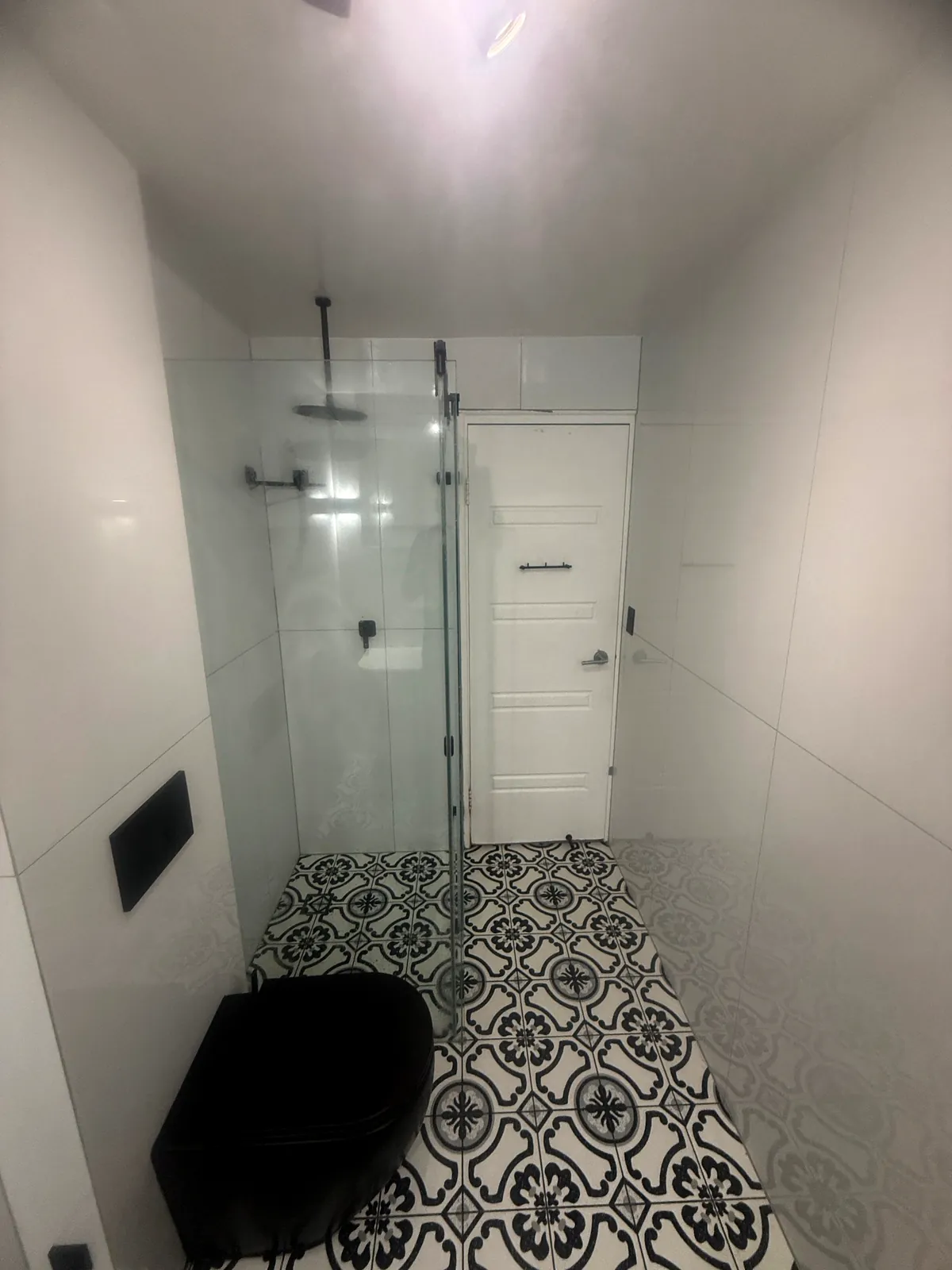 Bathroom renovation, patterned floor tile and black wall-hung toilet