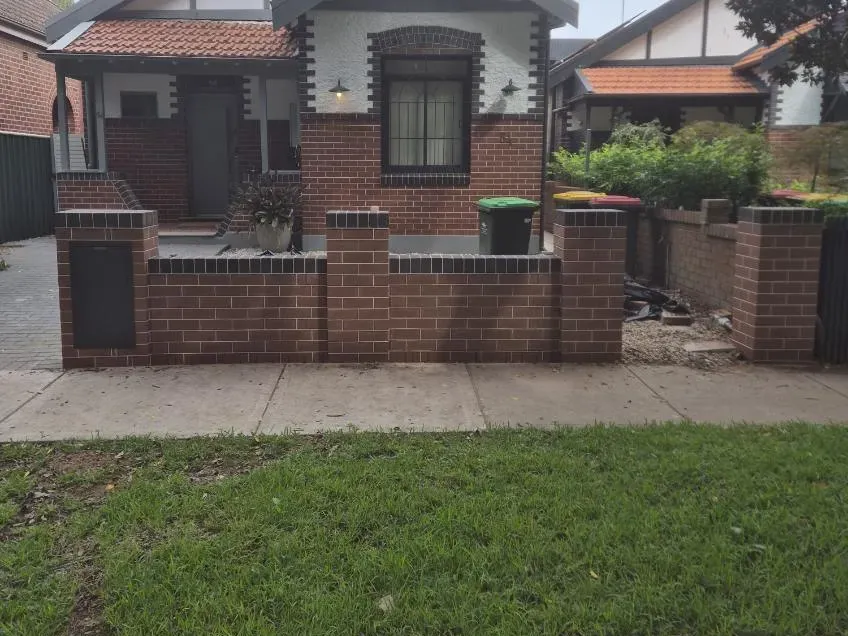 Brick front fence with piers and gate, Federation-style cottage