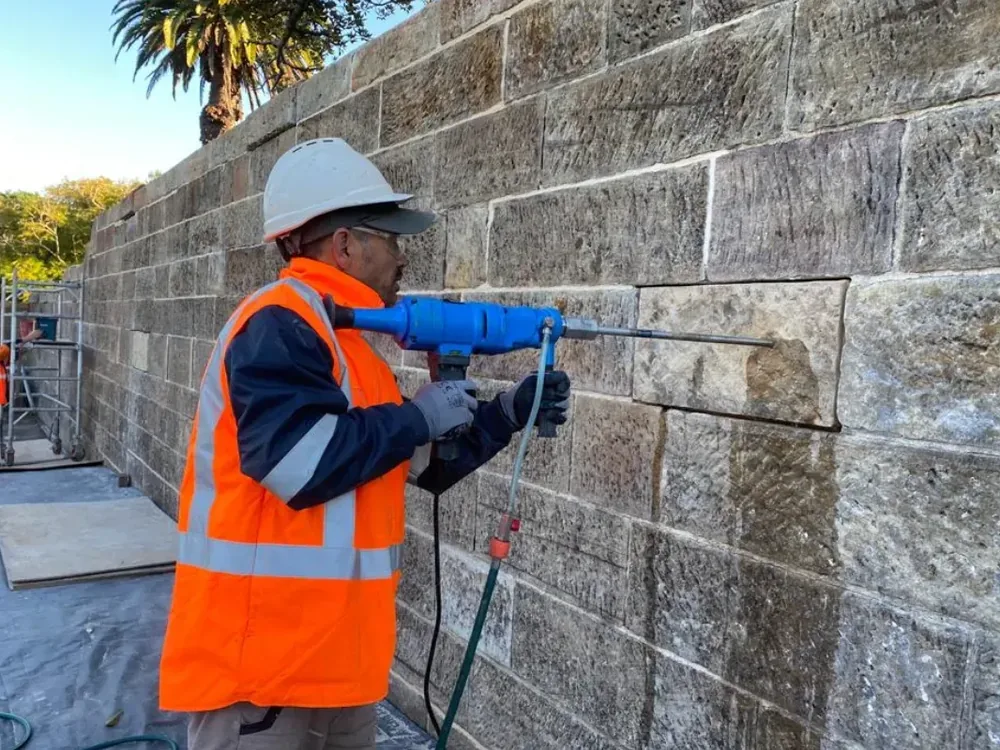 Core drilling into a heritage sandstone wall during restoration