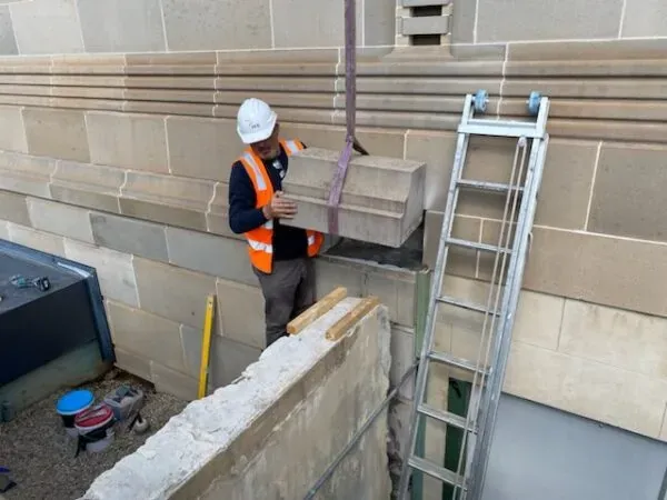 Lifting a sandstone block into place on a heritage stone building